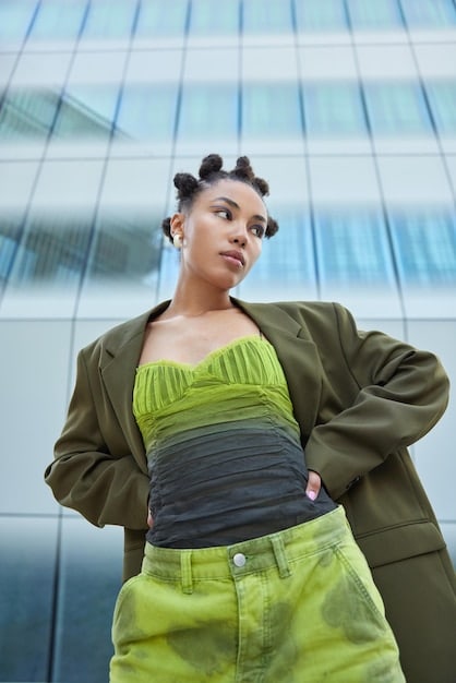 A side-by-side comparison of Lizzo with vibrant, flattering blue hair and Machine Gun Kelly with a less successful neon green hairstyle, emphasizing the impact of color choices on overall appearance.