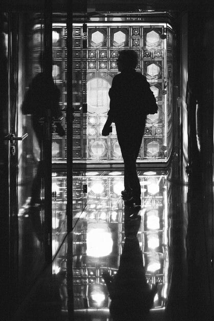 A silhouette of a celebrity surrounded by flashing cameras, conveying the intense scrutiny and constant surveillance they face, highlighting the ongoing battle for privacy.