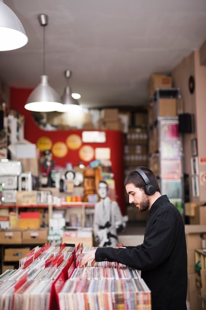 An interior shot of a modern record store, showcasing well-organized shelves filled with vinyl records. Customers are browsing and interacting with the merchandise.