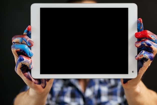 A close-up shot of a person's hands holding a tablet displaying a vibrant digital comic page, contrasted with a blurred background of physical comic books.