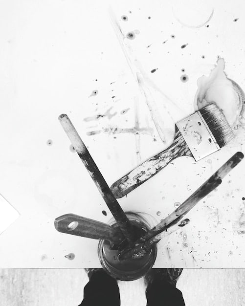A split image showing traditional comic book inking tools (brushes, pens, ink) on one side, contrasted with a digital drawing tablet and stylus on the other, symbolizing the blend of traditional and modern techniques in contemporary comic art.