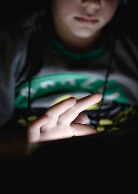 A close-up shot of a young esports player looking concerned while reading a document, possibly a contract. The background is blurred, focusing attention on the player's expression of worry.