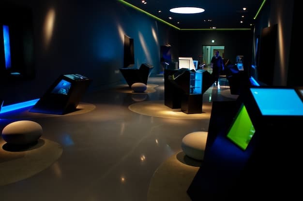 A wide shot of a mobile esports event venue, showing a stage with multiple gaming stations, large screens displaying the gameplay, and a lively audience watching the competition. The venue is branded with logos of sponsors and game developers, highlighting the professional nature of the event.